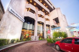 Klandasan Kecil的住宿－Adika Hotel Bahtera，停在大楼前的红色汽车