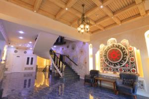 un vestíbulo con una escalera y una pintura en la pared en Ayniу Hotel en Samarcanda