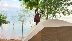 a white tent in front of a body of water at BOHO Glamping in Ấp Phú Cát