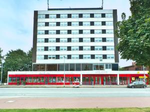 a large building with a red and white building at Wiking Hotel in Henstedt-Ulzburg