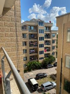 a parking lot with cars parked in front of a building at maasaifari cozy homes in Dar es Salaam