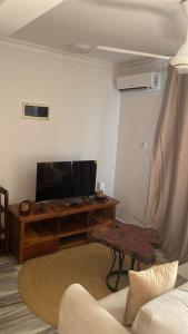 a living room with a flat screen tv and a couch at maasaifari cozy homes in Dar es Salaam