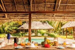 - une table avec de la nourriture et des fruits dans un pavillon dans l'établissement The Cabanas, Anasa Hotels & Experiences, à Matondoni