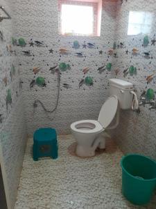 a bathroom with a toilet and a wall covered in debris at hotel sudhara in Tirukkadaiyūr