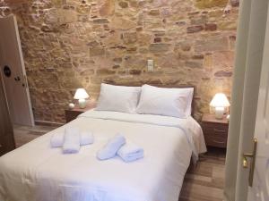 a bedroom with a white bed with towels on it at CityZen Rooms Chios in Chios +17 photos
