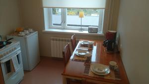 een keuken met een houten tafel en een raam bij K15HOSTEL guest apartments in Kobela