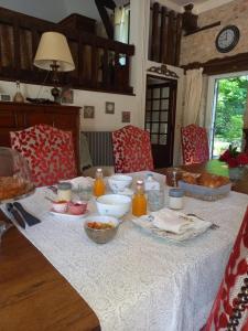 uma mesa com uma toalha de mesa branca com comida em LES TALOCHES em Tourtoirac