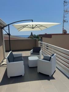 a patio with two chairs and an umbrella at Perla Marina 2 Acitrezza in Acitrezza