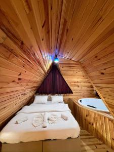 a bed in a wooden room with a tub at Five Stars Apart in Trabzon