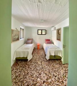 two beds in a room with a carpet at The Bellhouse Kranidi in Kranidi +12 photos