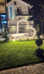 een auto geparkeerd voor een huis 's nachts bij VILA AARON in Durrës