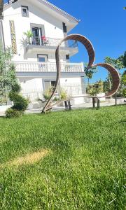 a sculpture in the grass in front of a building at VILA AARON in Durrës