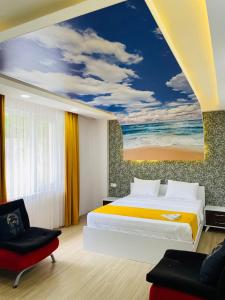 1 dormitorio con 1 cama y una pintura de la playa en deperlas en Atakum