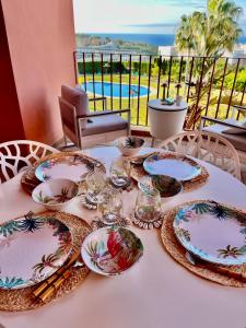 una mesa con platos y vasos encima en Estrella de Mar zeezicht en uitkijk op Gibraltar 40m2 terras incl zwembad Las Garzas Manilva, en Manilva