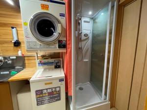um chuveiro numa cozinha com uma máquina de lavar roupa em Tsuyukusa em Takayama
