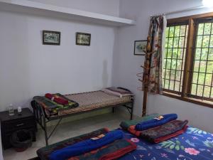 Habitación con 2 camas y ventana en Siderbhan Homestay en Chikmagalūr