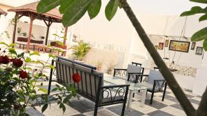 a patio with benches and a table with roses at Stylish 3BHK Penthouse W/Terrace Steps from EON IT in Pune