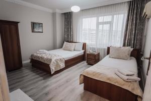 a hotel room with two beds and a window at Samsun Charme Hotel in Samsun