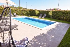 una piscina con un tobogán en un patio en Luxury apartment Grotta with sea view and swimming pool en Premantura