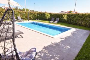 basen ze zjeżdżalnią na dziedzińcu w obiekcie Luxury apartment Grotta with sea view and swimming pool w mieście Premantura