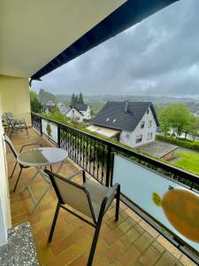 balcón con mesa, sillas y vistas en Ferienhaus Dobias, en Kelberg