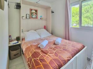 een slaapkamer met een groot bed en handdoeken bij A 5 min de la plage, proche du canal in Le Grau-du-Roi