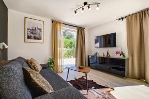 a living room with a couch and a tv at VILLA RITA ARTaTORE in Mali Lošinj