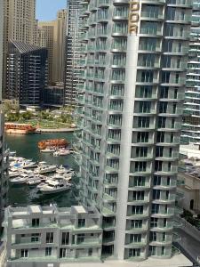 un gran edificio blanco con barcos en el agua en Elite Luxury - Spacious 2BR Apt 1517 Sqft in Dubai Marina Both bedroom Ensuite Walking to Metro Restaurants Beach Mall Marina walk, en Dubái