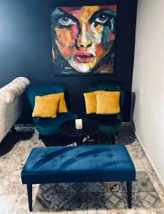 a room with two chairs and a painting of a woman at Rooms & Apartment ZALA Airport shuttle option in Cerklje na Gorenjskem