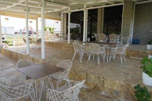 a group of tables and chairs on a patio at Hotel Monte Rei in Lushnjë