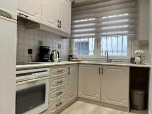 a kitchen with white cabinets and a sink and a window at Chios City Dwelling in Chios