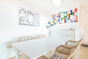 uma sala de jantar branca com uma mesa e cadeiras brancas em Apartment in Muralla Roja - 0406 em Calpe