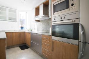 a kitchen with stainless steel appliances and wooden cabinets at Apartment in Muralla Roja - 0406 in Calpe +11 photos
