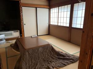 a room with a table and two windows at Futago Cabin in Minami Uonuma