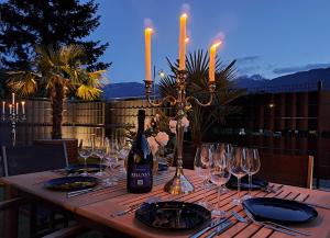 a table with a bottle of wine and wine glasses at Guesthouse Le Palme in Postal