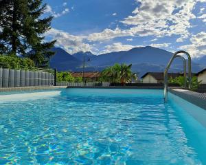 una piscina con una montaña en el fondo en Guesthouse Le Palme, en Postal