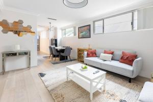 a living room with a couch and a table at Executive CBD Perth House 4BR 3BA 2Pk SLEEP 8! in Perth