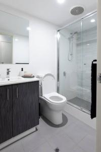 a bathroom with a toilet and a shower and a sink at Executive CBD Perth House 4BR 3BA 2Pk SLEEP 8! in Perth +14 photos