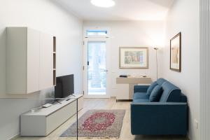 Una sala de estar con un sofá azul y un televisor. en Cairoli Lifestyle, en Fano