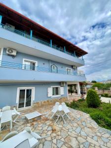 un edificio con sedie bianche e un patio di Vila Elite a Ksamil