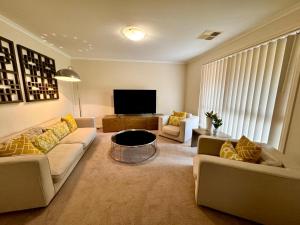 uma sala de estar com 2 sofás e uma televisão de ecrã plano em Adelaide Hills 4 bed home near Hahndorf Mt Barker 