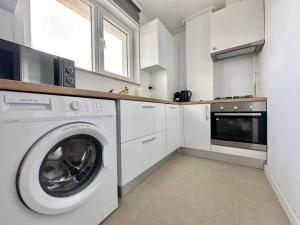 a white kitchen with a washer and dryer at Double Studio B601 StayInn by Cosmopolis in Ştefăneştii de Jos