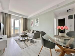 a living room with a glass table and a couch at Double Studio B601 StayInn by Cosmopolis in Ştefăneştii de Jos