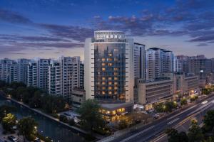 a view of a building in a city at night at UrCove by Hyatt Tianjin West Railway STN in Tianjin