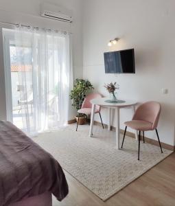 巴斯卡的住宿－King's Apartment，一间卧室配有桌椅和电视。