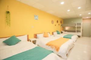 two beds in a room with yellow walls at 小巷微光 in Green Island