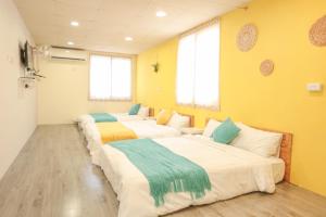 3 camas en una habitación con paredes amarillas en 小巷微光, en Isla Verde