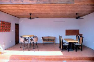a patio with tables and chairs and a wooden ceiling at Homely stay in the heart of Osu - Studio 2 in Accra