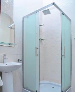 a bathroom with a glass shower and a sink at Homely stay in the heart of Osu - Studio 2 in Accra