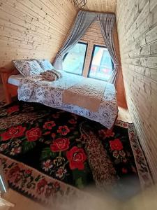 ein kleines Bett in einem Zimmer mit Fenster in der Unterkunft CarpatinA Rustic House in Runcu